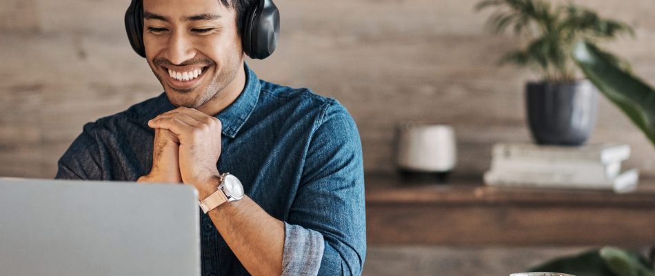 Man with headphones smiling during a video call or conference.