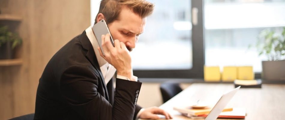 Business professional using a softphone on a laptop in an office setting.