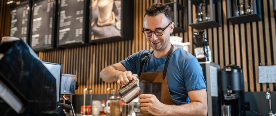 Barista pouring milk into coffee at a cafe counter in Jacksonville, Florida.